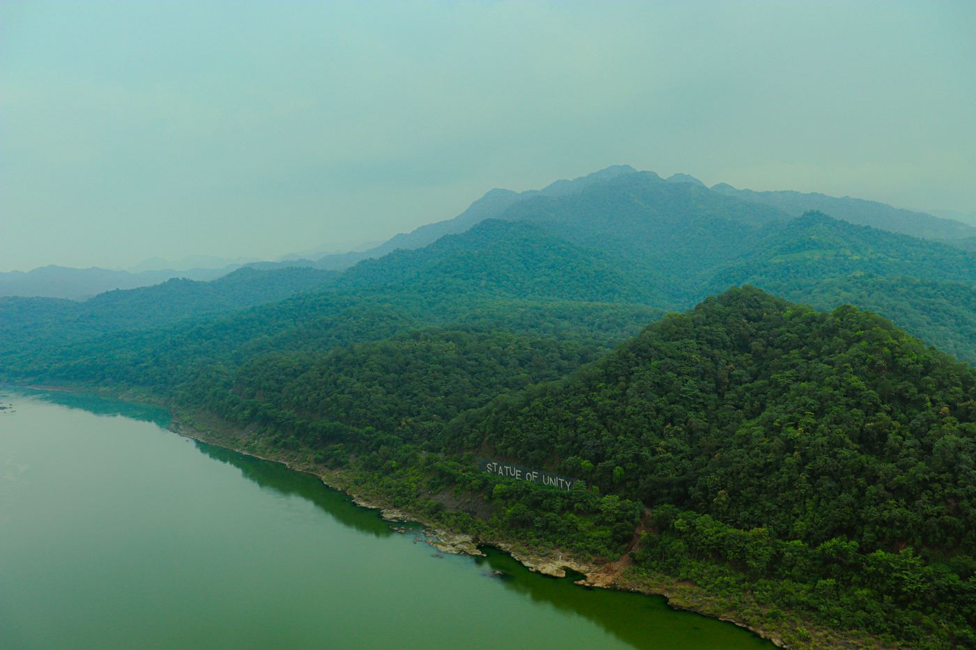Misty green hills over a lake